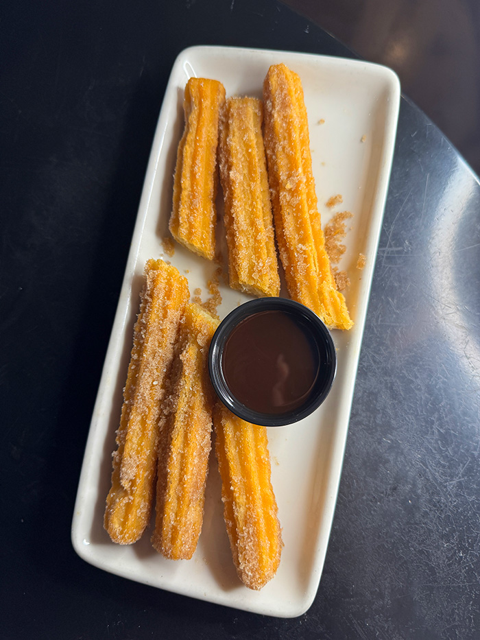 Cinnamon-sugar churros with a ramekin of warm chocolate dipping sauce